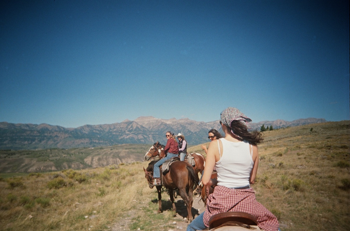 Friends on horseback in front of mountains